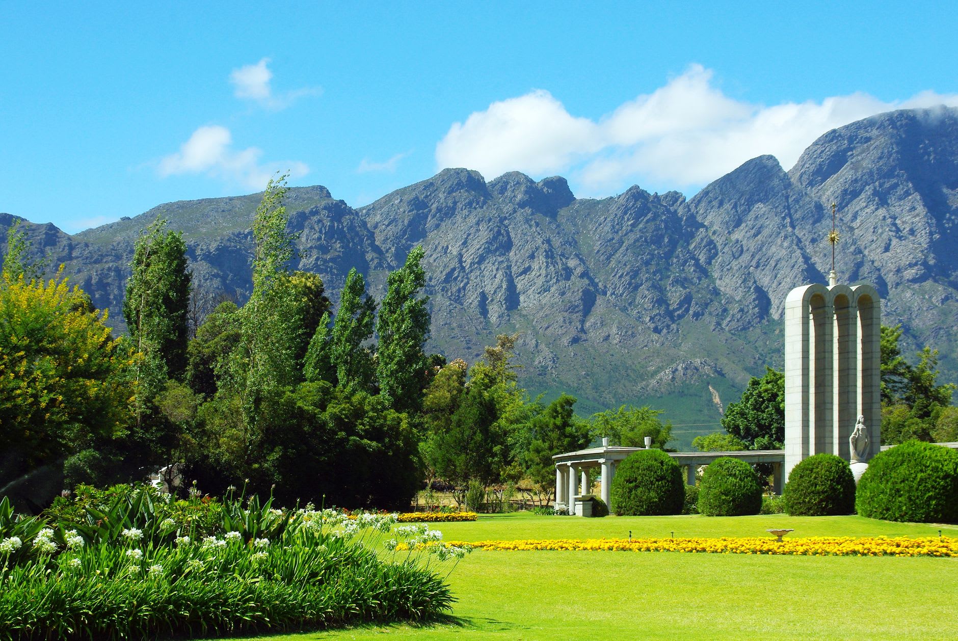 Viñedos extendiéndose hacia las montañas de Franschhoek bajo la luz dorada de la tarde