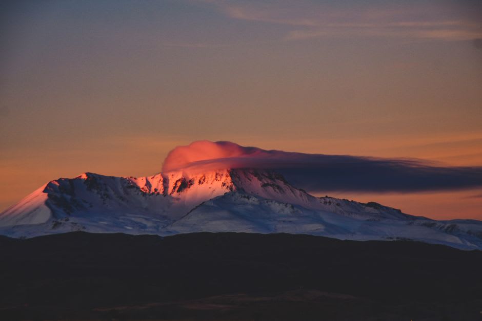 The distant silhouette of Erciyes volcano at sunset, seen from the fairy chimney valleys of central Cappadocia
