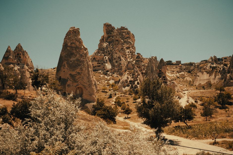 The interior staircase of Ortahisar's rock citadel, narrow steps cut through volcanic tufa toward openings that flood the passage with daylight