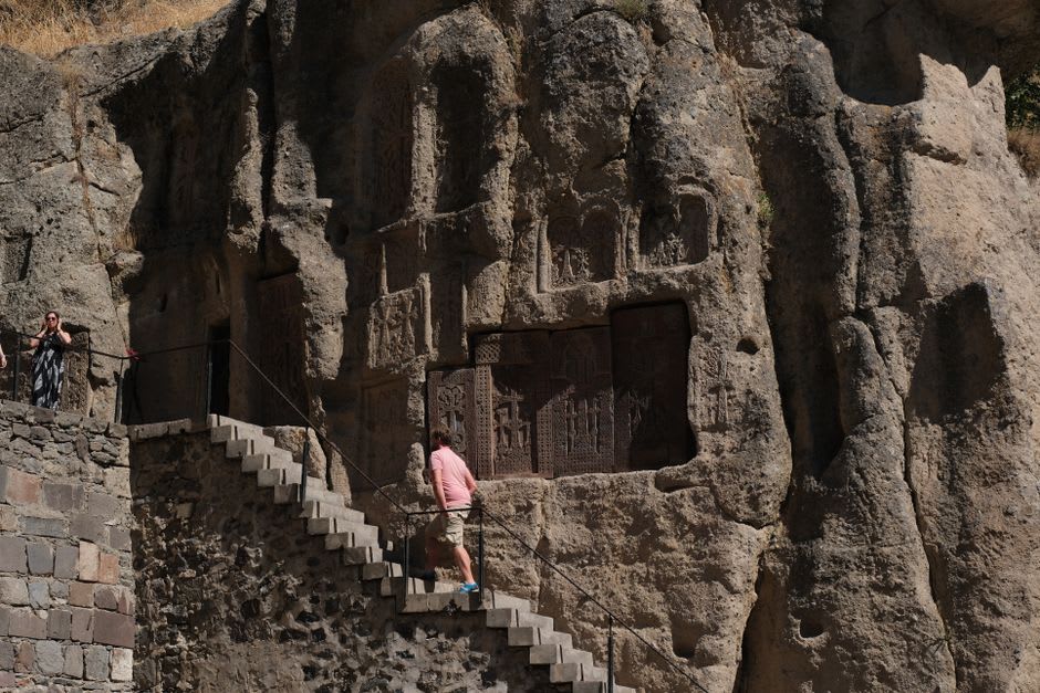 The cathedral-like main hall of Selime Monastery, its vaulted rock-cut ceiling rising far overhead with light falling through carved openings