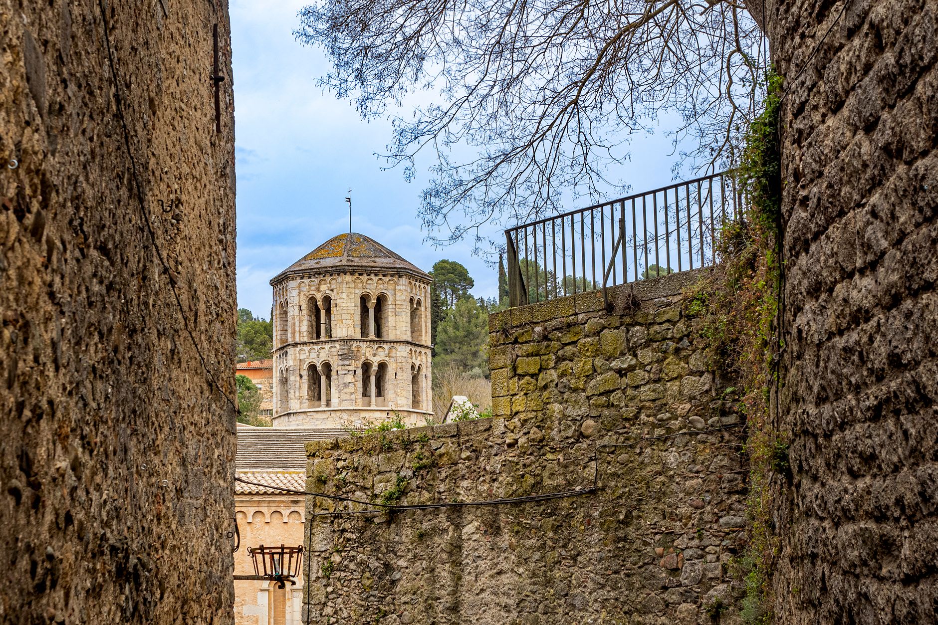 La plaza medieval de Besalú con la iglesia de Sant Pere elevándose detrás de los porches adoquinados
