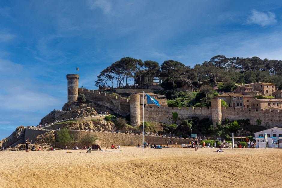 The old stone walls of Vila Vella catching the late afternoon light above the Mediterranean