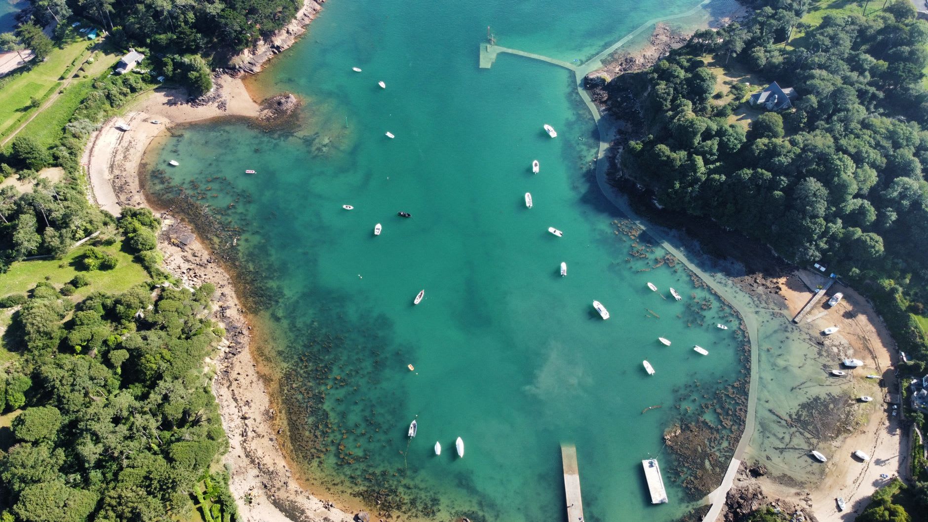 St. Brelade's Bay at low tide with the full expanse of pale sand visible and clear water at the shoreline