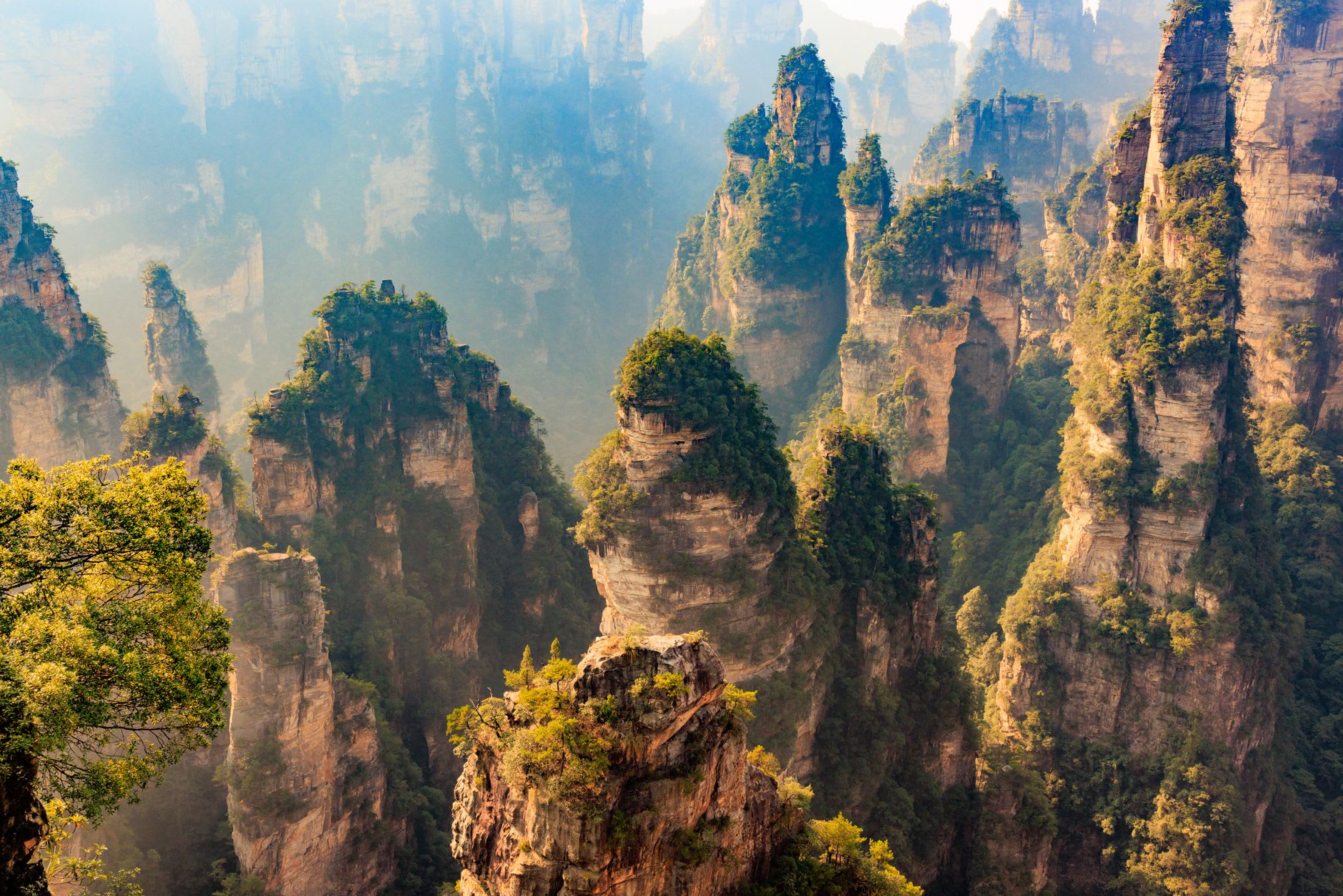 The approach walkway along the canyon cliff edge, with mist-covered sandstone pillars visible beyond