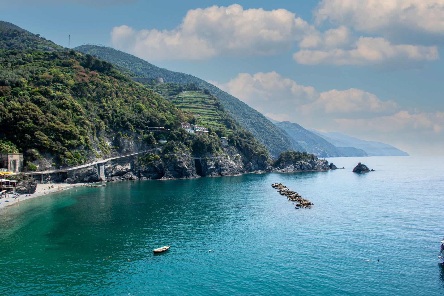 The steep trail descent to Guvano Beach through Cinque Terre maquis, the cove appearing below through the scrub