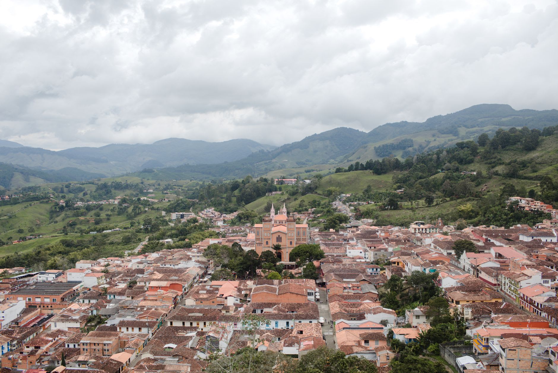 The unpaved road ascending to Buenavista, with coffee farms terraced into the steep hillsides on either side