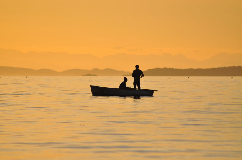 Fishermen checking nets at dusk in the shallow lagoon waters near Palmerston