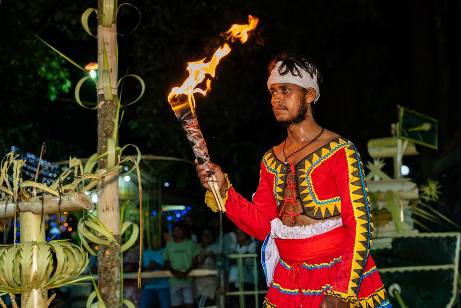 Traditional dancers on the illuminated over-water stage at Te Vara Nui Village during the evening show