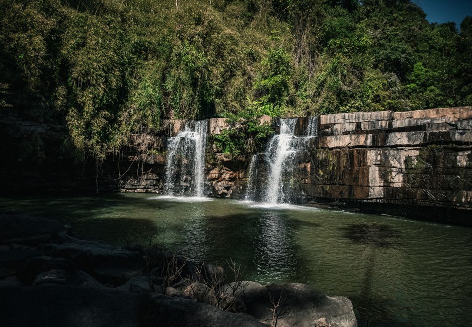 A short waterfall dropping into a clear jungle pool at Wigmore's Waterfall on Rarotonga