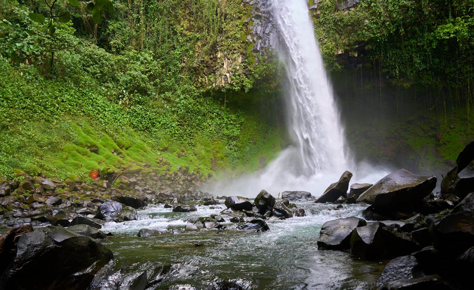 Dramatic waterfall cascading into a lush tropical pool