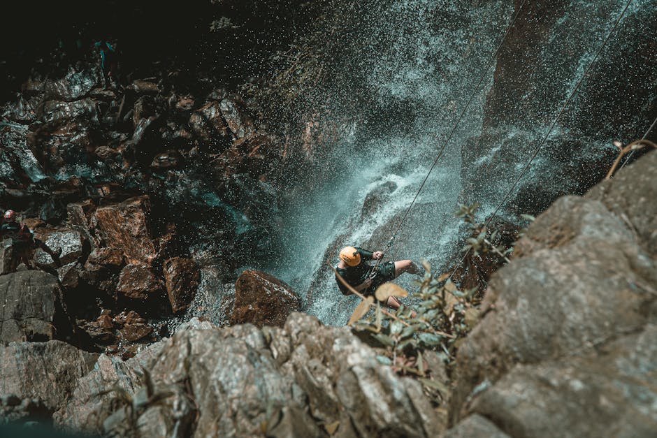Rappelling down a waterfall surrounded by tropical greenery