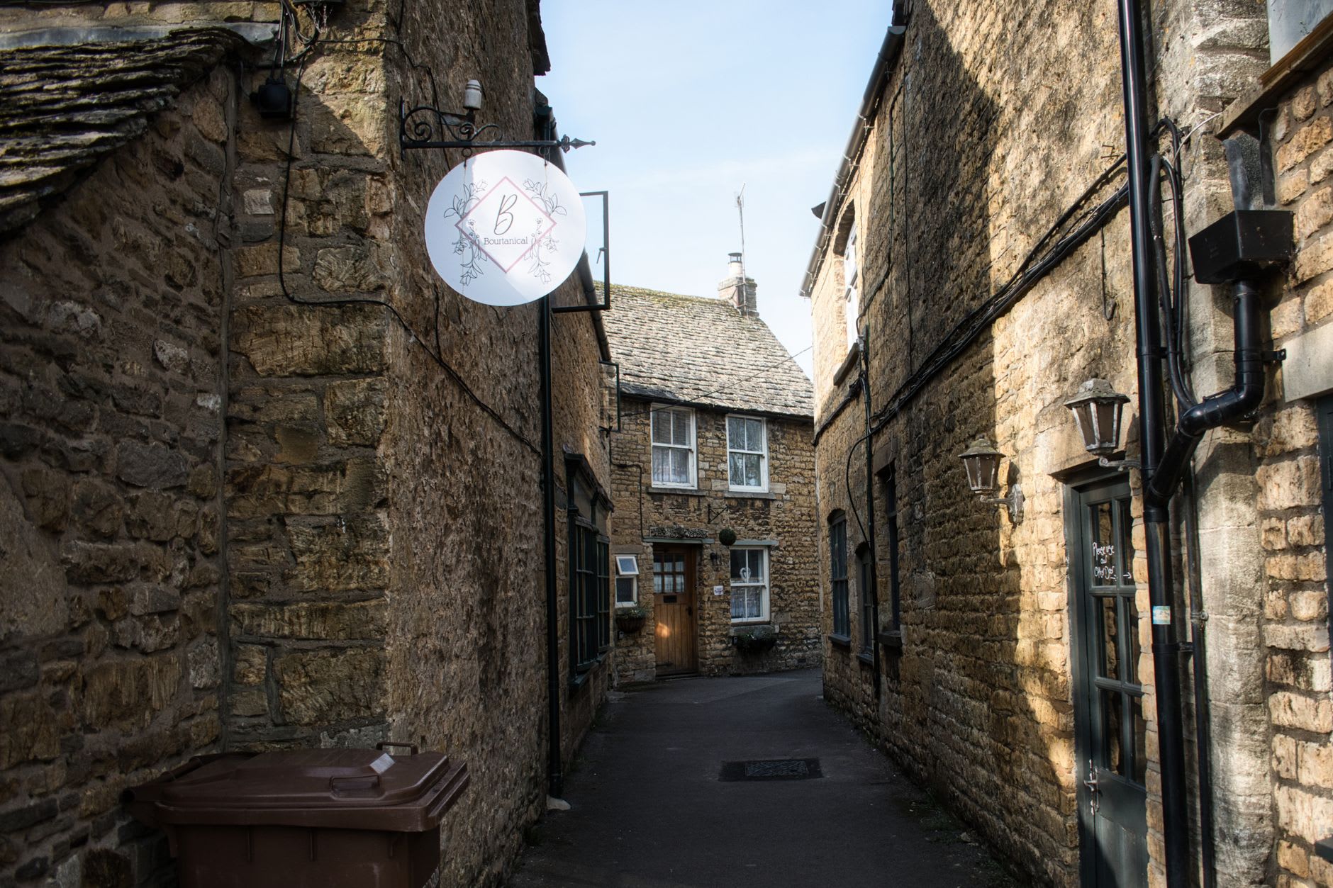 Interior de Snowshill Manor — una de las habitaciones de Charles Wade repleta del suelo al techo de objetos antiguos, armadura samurái en una entrada