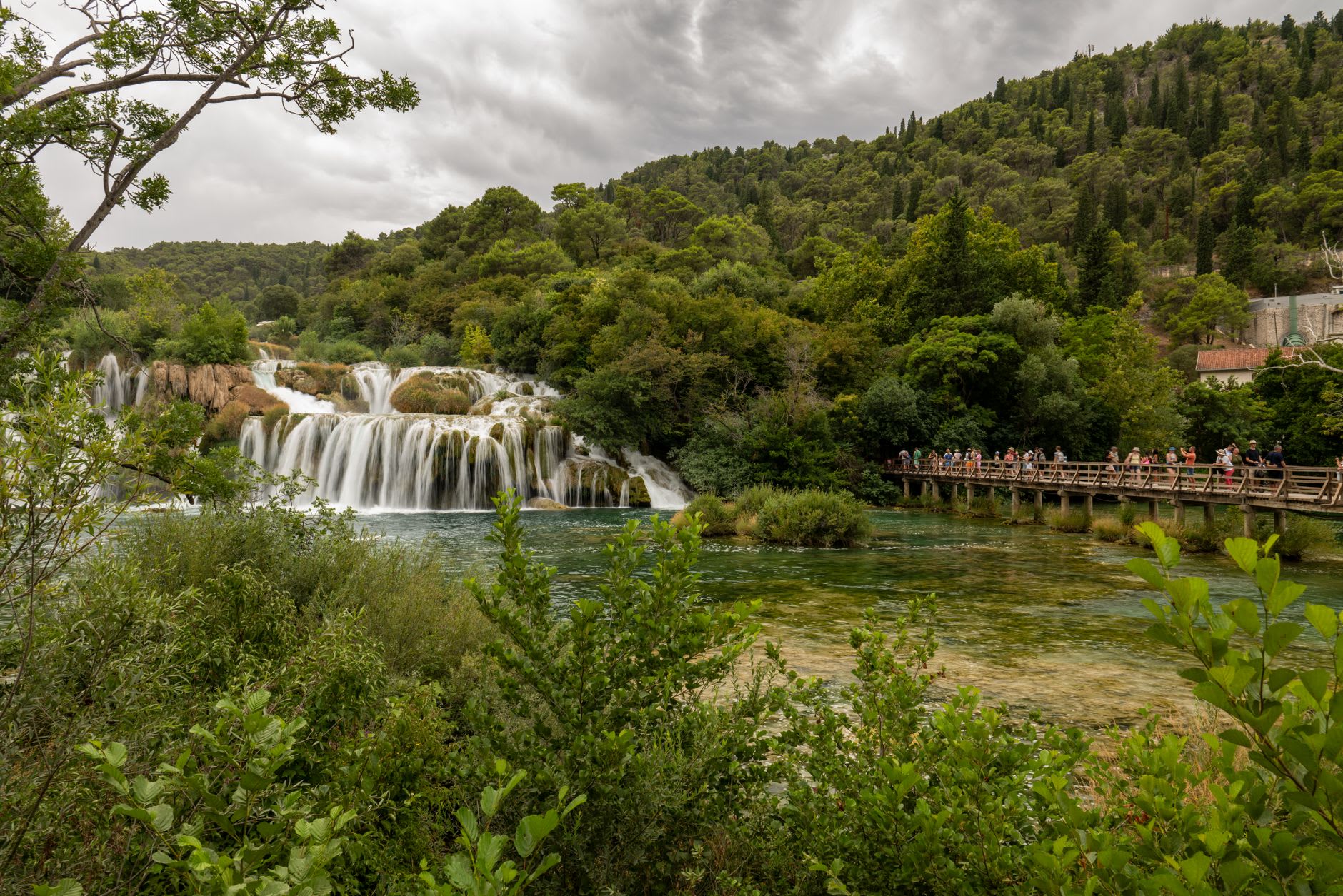 The island monastery of Visovac with its white walls and cypress trees, surrounded by the calm green Krka River