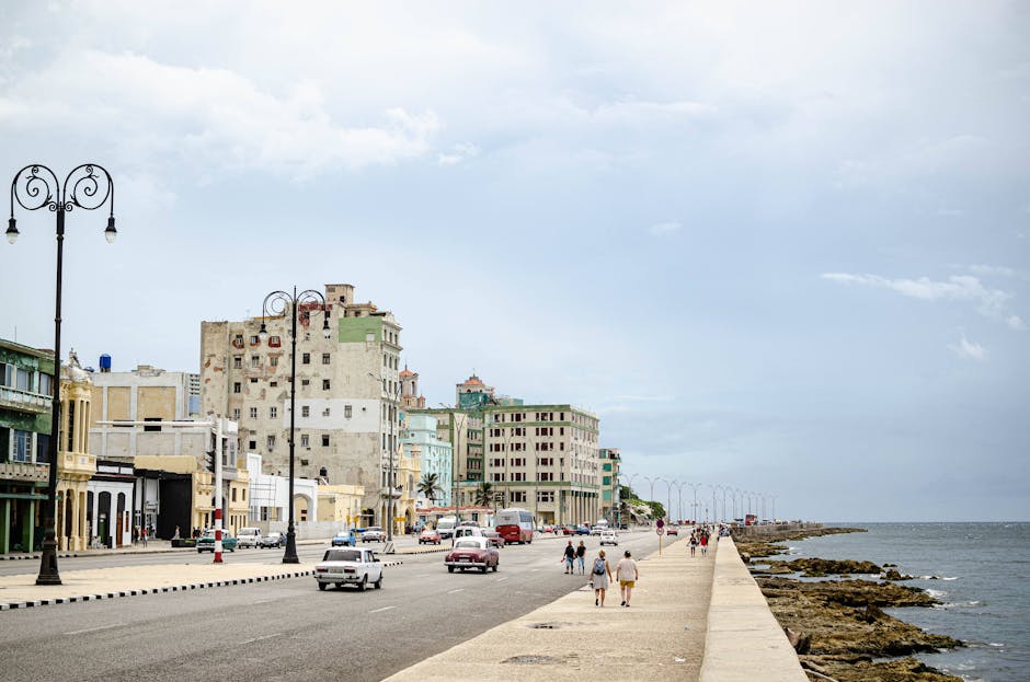 The Havana Malecon at golden hour with waves crashing against the seawall