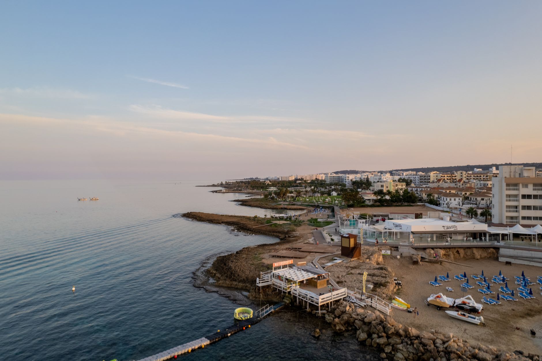 The great Venetian walls of Famagusta, limestone bastions rising above the city, the sea visible beyond, a lone figure walking along the top