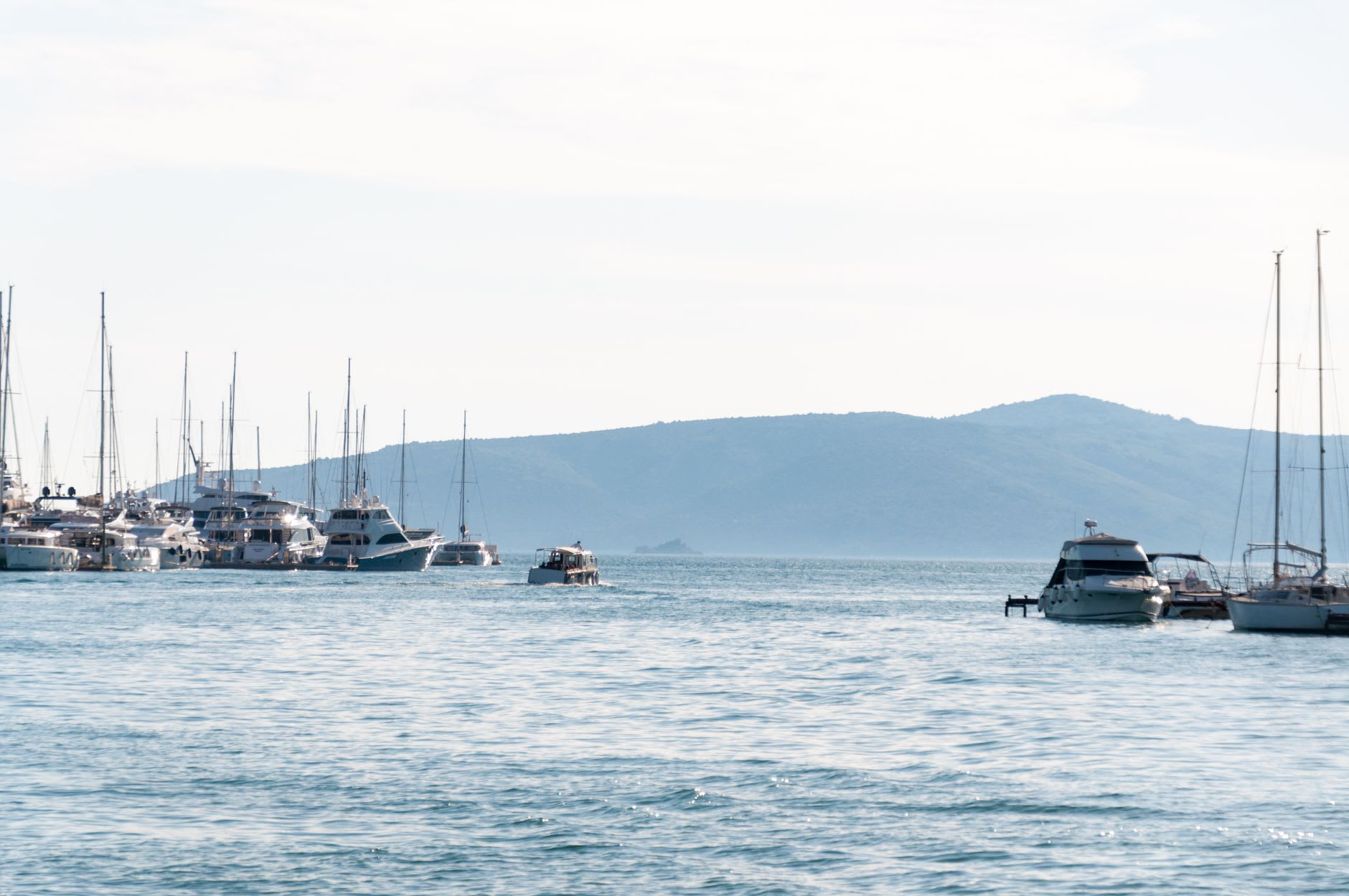 La baie abritée du port principal de Lastovo tôt le matin, bateaux de pêche à l'ancre dans une eau si calme qu'elle reflète leurs silhouettes