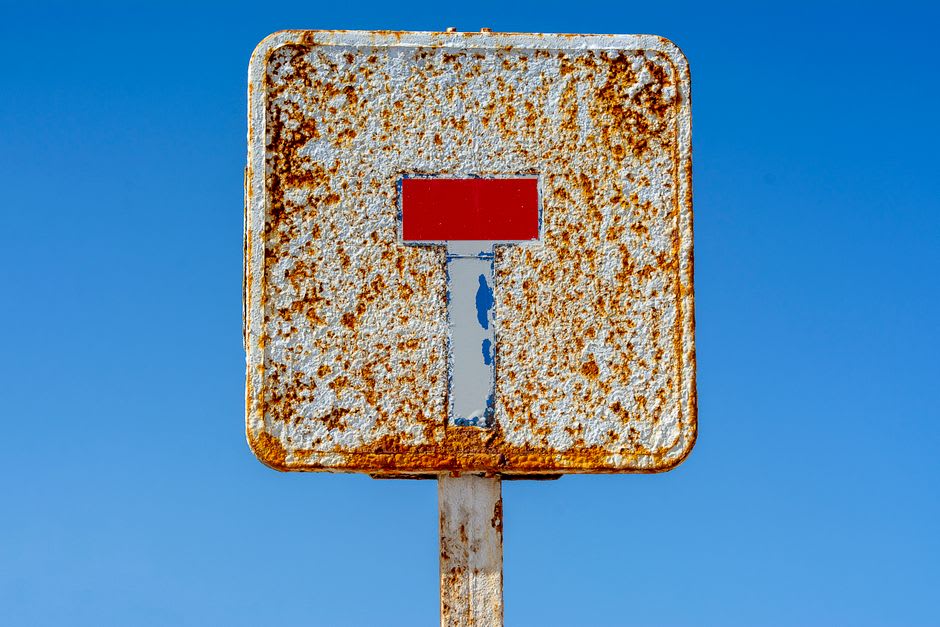 A weathered sign along the Kalia Beach walkway marking a historical Dead Sea water level, now far from the current shoreline