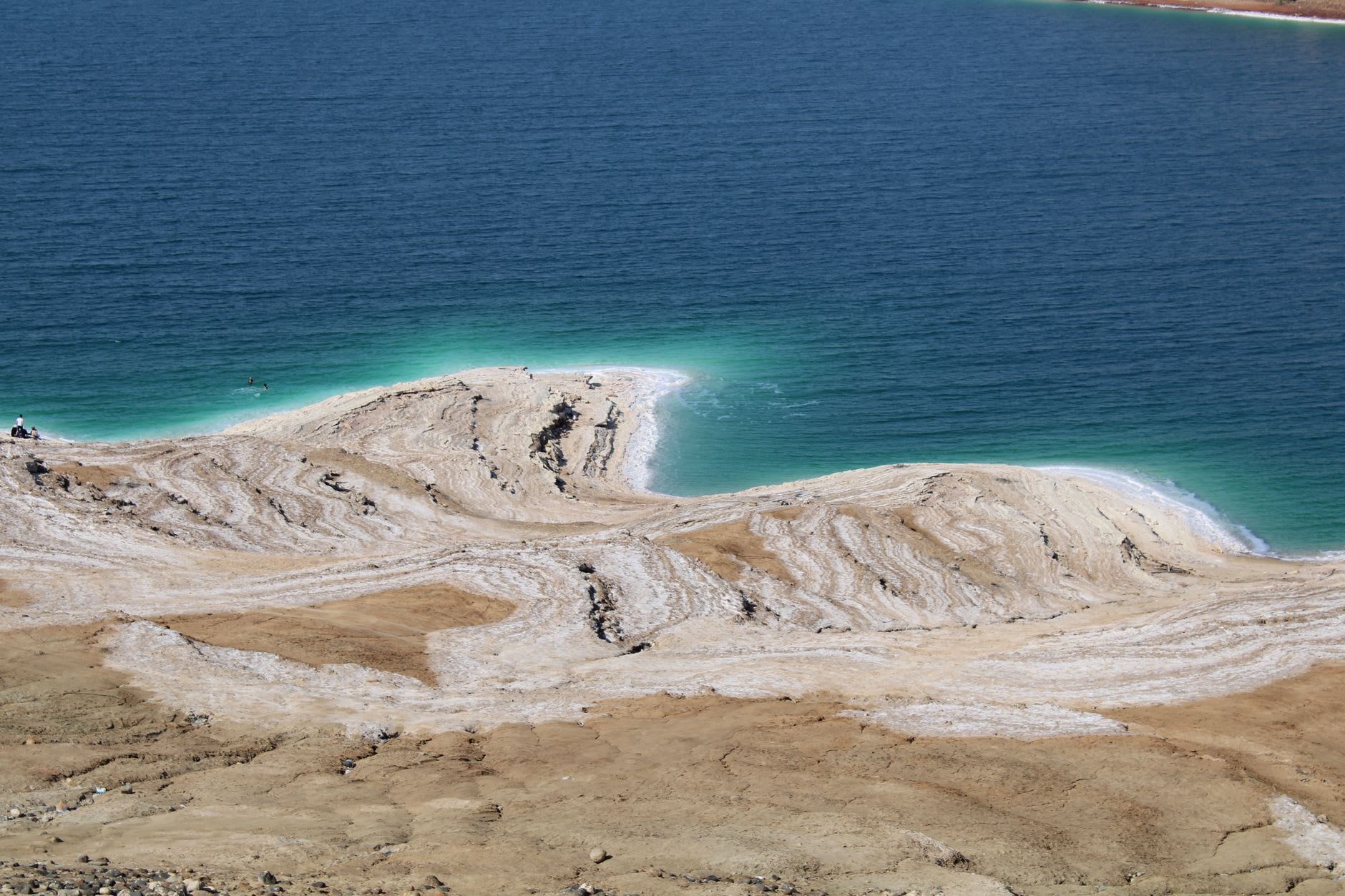 La vista desde las almenas del Castillo de Karak hacia el oeste sobre el Mar Muerto, el agua quieta muy abajo y las colinas de Cisjordania en el horizonte
