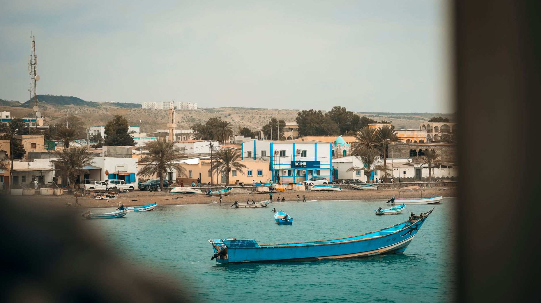 The white-painted mosques and palm-lined waterfront of Tadjoura town seen from the ferry deck