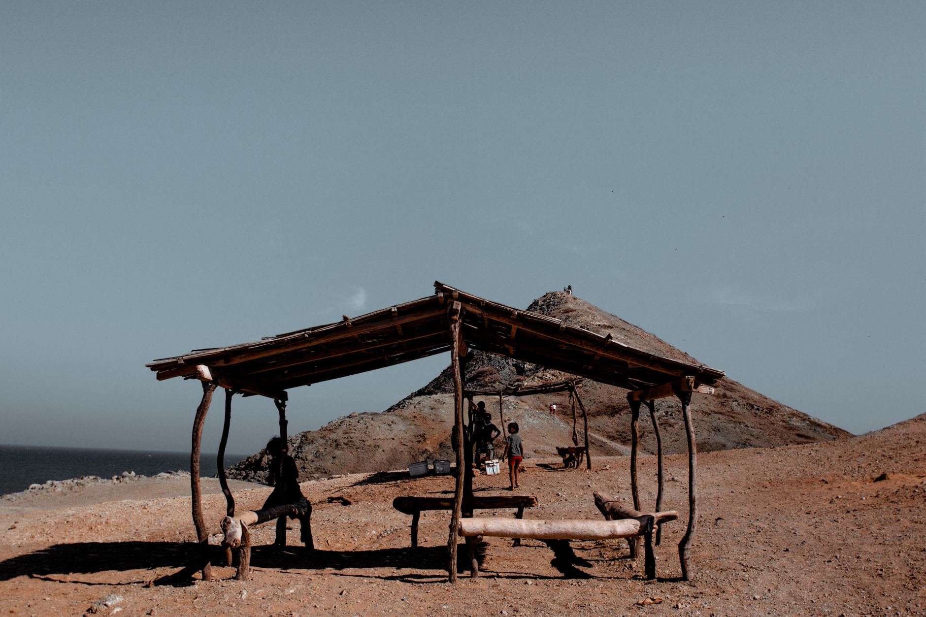 Les bungalows du lodge au crépuscule sur l'île Moucha, les lumières lointaines de Djibouti-Ville reflétées dans l'eau plate
