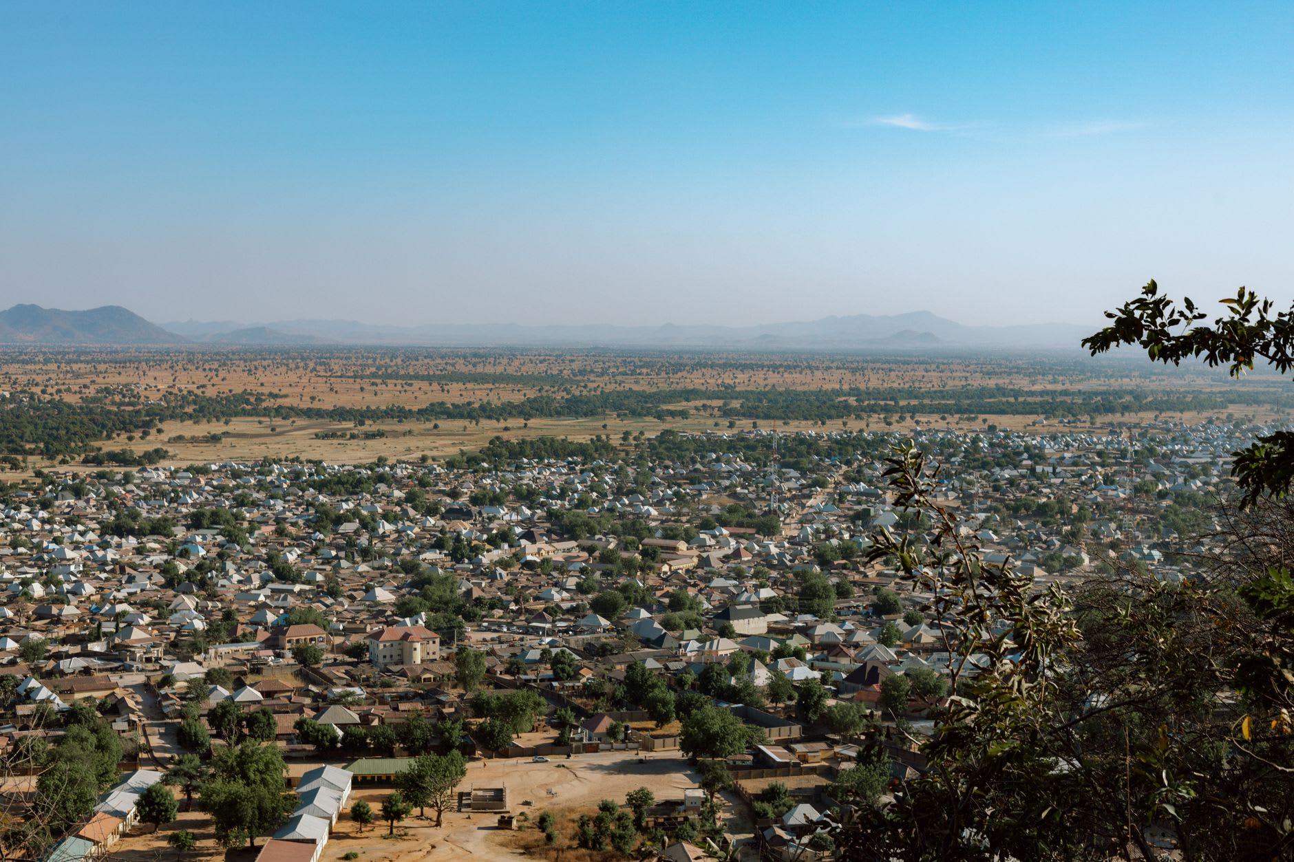 The Bandiagara escarpment viewed from the edge of town at dawn, its sandstone face glowing amber against a pale sky