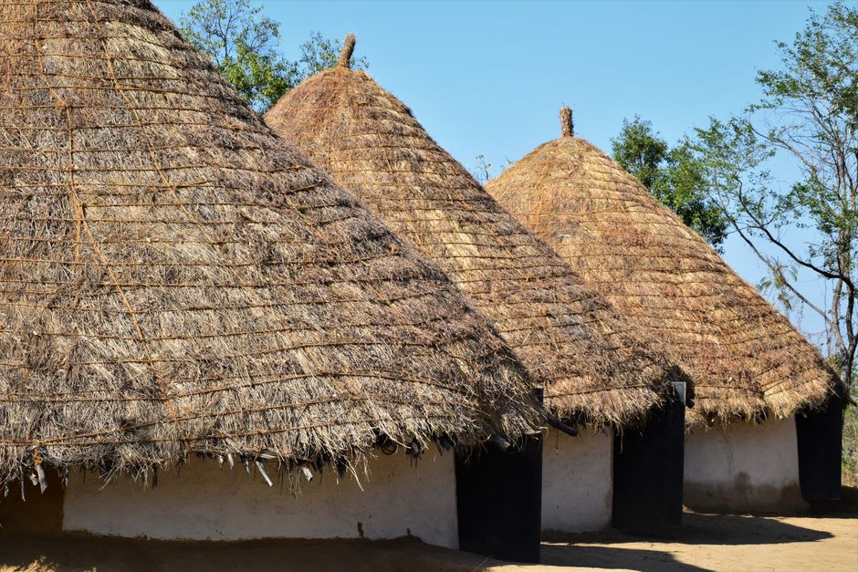 Traditional Dogon granaries with conical thatched roofs at the cliff edge in Dourou