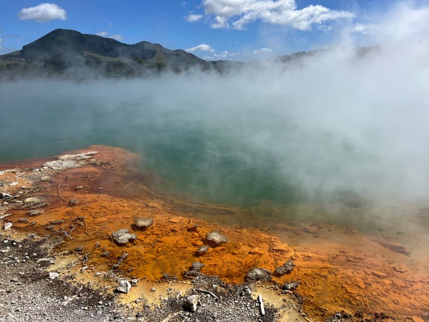 Poza termal de azufre con paredes de piedra en Wotten Waven, con vapor elevándose sobre la superficie del agua