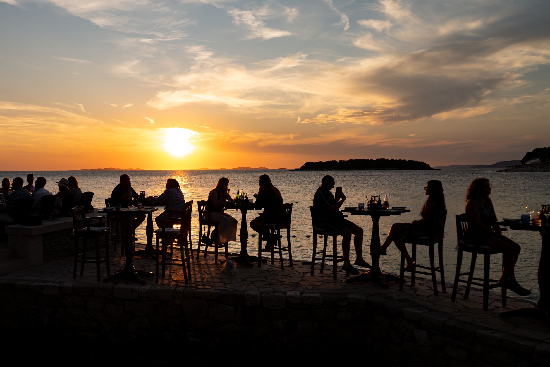 Wooden tables at an outdoor restaurant in the Pueblo de los Pescadores at dusk