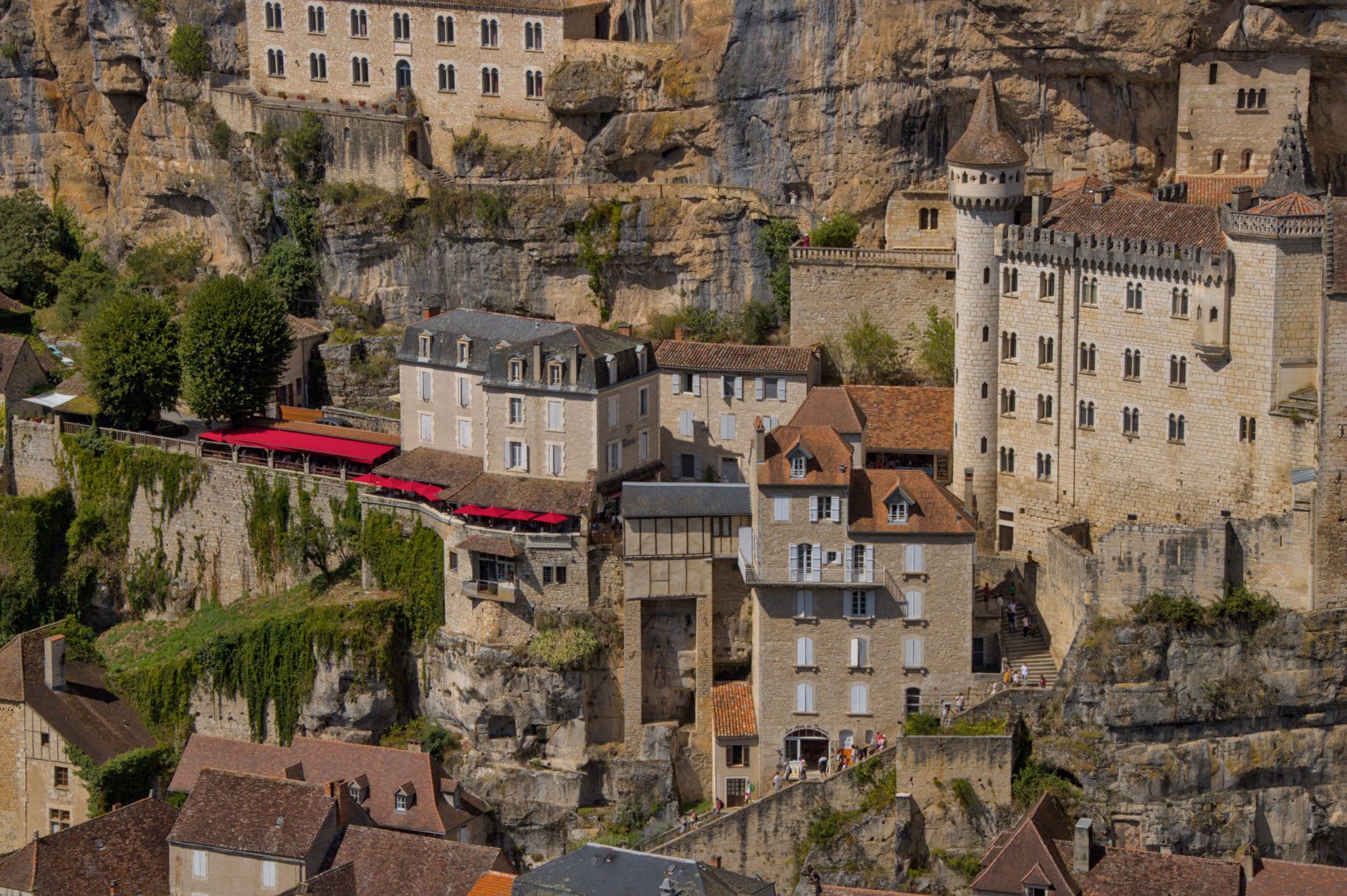 Rock overhangs and troglodyte shelters built into the limestone cliff face above the Vézère river at Les Eyzies
