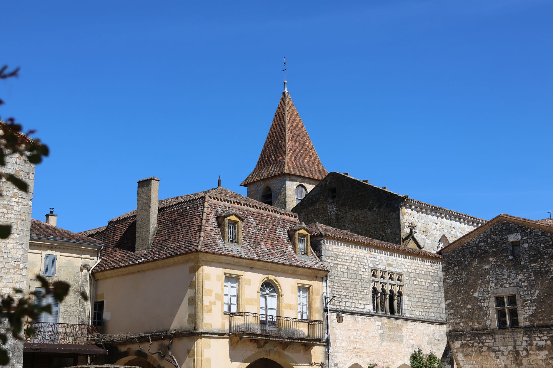 Stone towers and lanterns of Sarlat's old town glowing under amber evening light