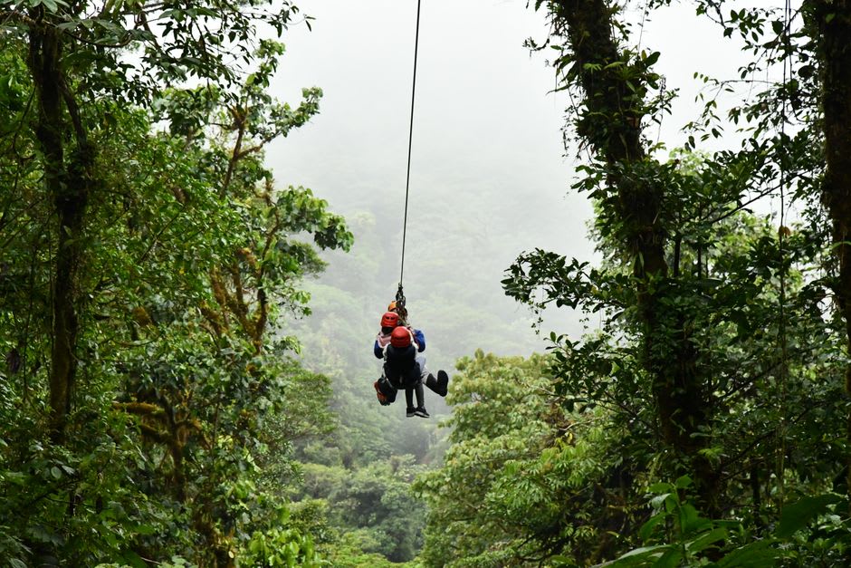 Un cable de tirolesa extendiéndose a través de un barranco de bosque nuboso brumoso cerca de Apaneca