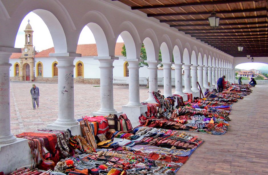Artisan stalls selling embroidered textiles and woven goods at the Saturday market in Ataco's central plaza