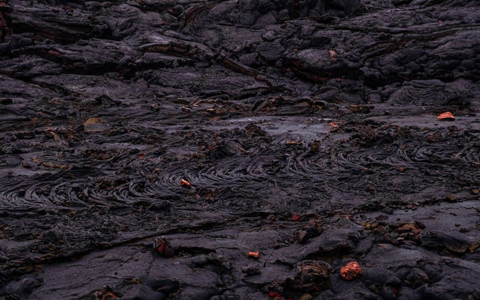 A frozen black lava flow fanning out across the lower slopes of Izalco volcano
