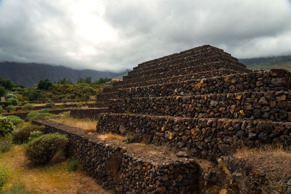 The stepped terraces of the main Tazumal pyramid structure with carved stonework visible on its facade