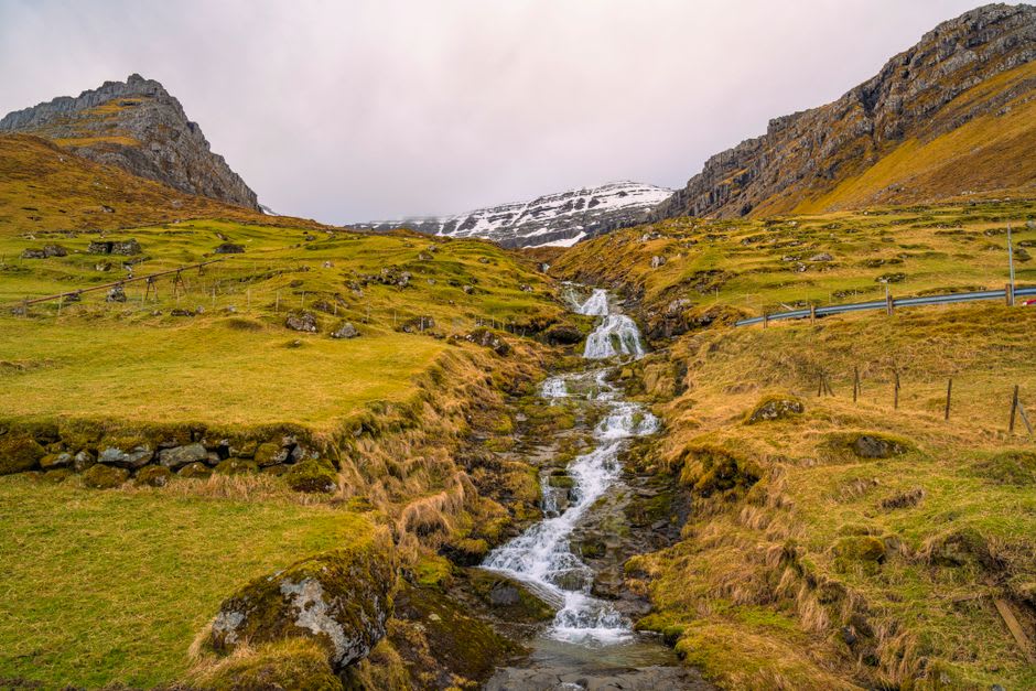 Fossá waterfall's upper tier emerging from a hanging valley above Streymoy