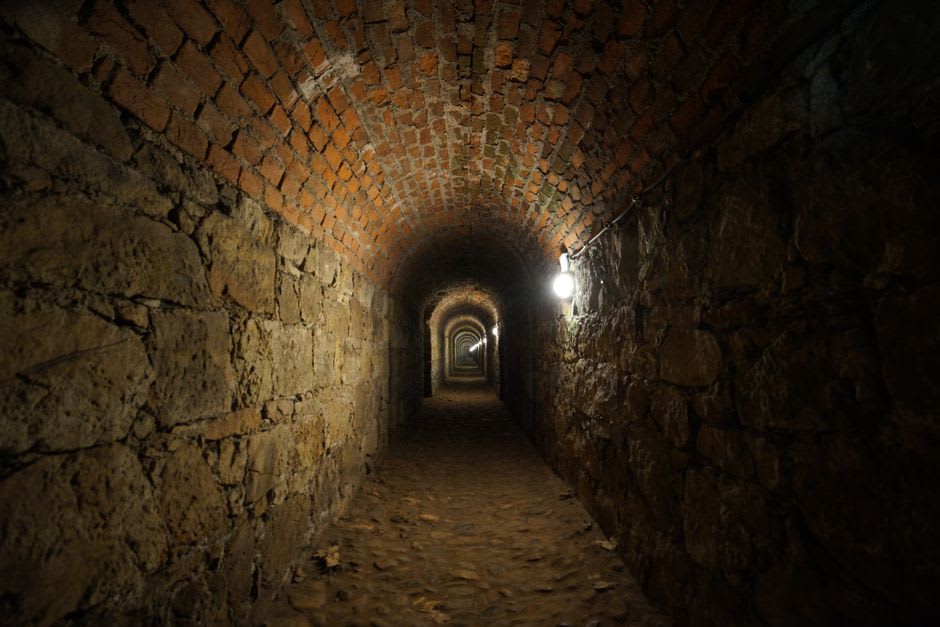 A local resident walking through a stone tunnel inside the Suomenlinna fortress