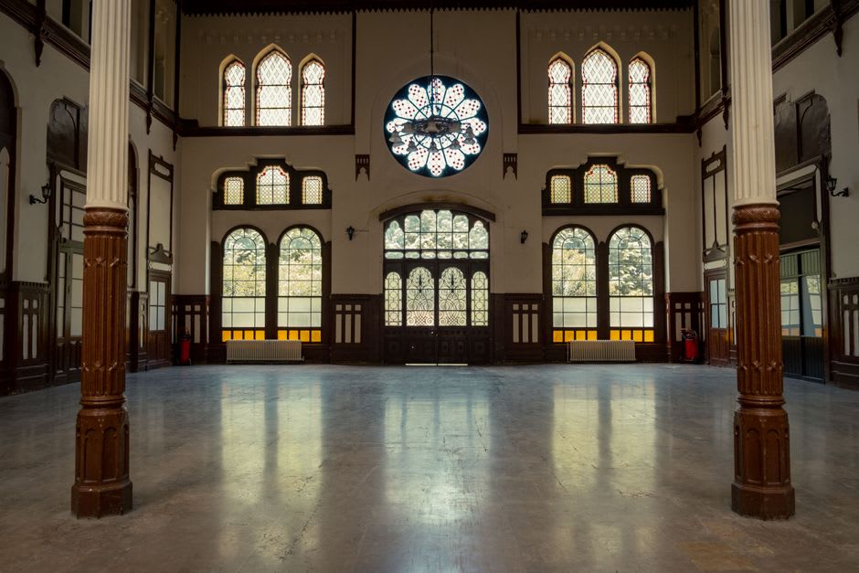 A grand marble hall inside the Thermes Nationaux spa building in Aix-les-Bains with brass fittings and arched windows