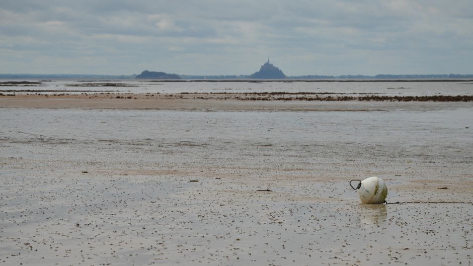 The distant silhouette of Mont-Saint-Michel seen across the sand flats of the bay from the Avranches belvedere