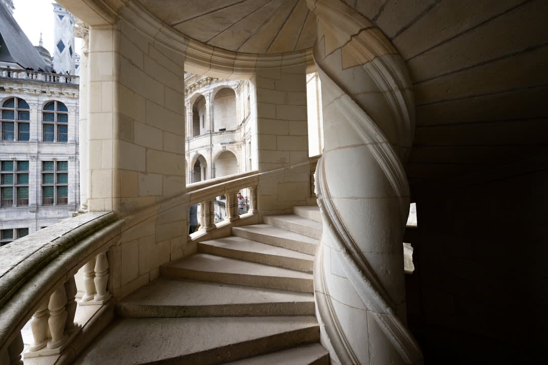 The open Italian-style staircase inside Azay-le-Rideau, lit by tall mullioned windows on each landing