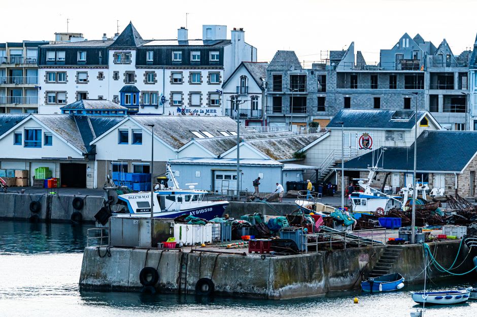 Grey granite fishermen's houses lining the small harbour quay of Barfleur