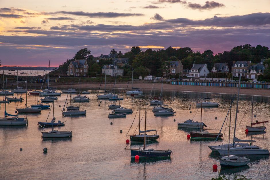 The Belle Époque harbor of Beaulieu-sur-Mer with pastel buildings and boats moored along the quay