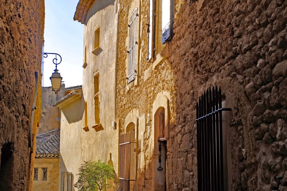Turreted dark-stone houses lining a narrow medieval street in Besse-et-Saint-Anastaise