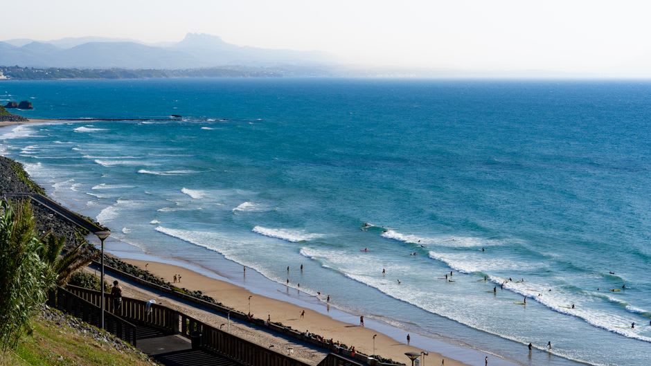 Surfers paddling out into Atlantic swells at the Côte des Basques beach in Biarritz