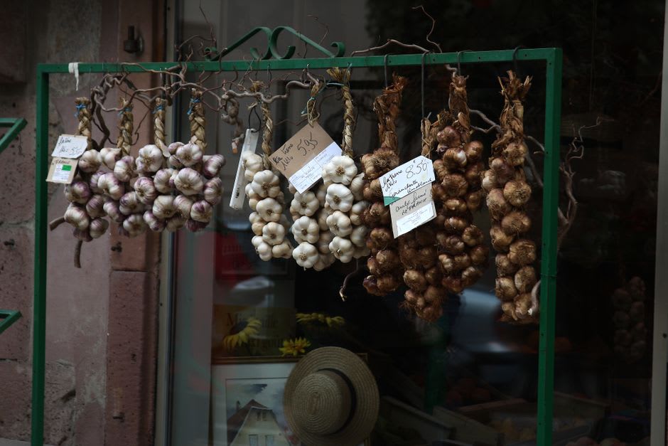 Braided strings of pink Billom garlic hanging outside a shopfront in the old town