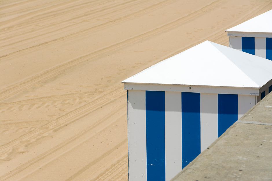 The curving sandy beach and boardwalk of Cabourg lined with striped bathing cabins
