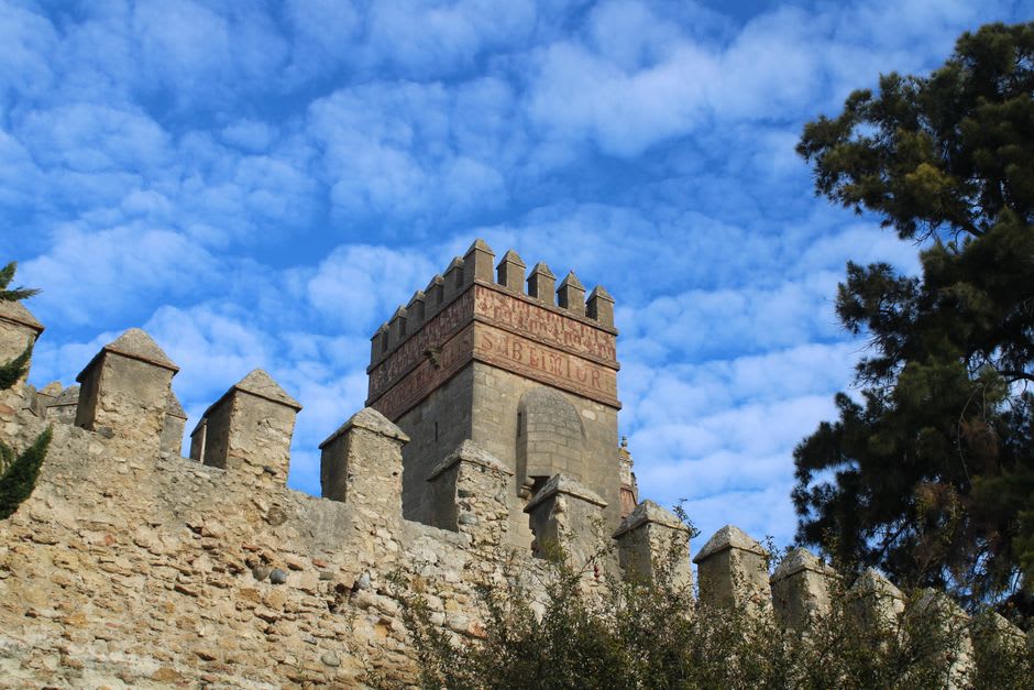 Close view of one of the three fortified towers of the Pont Valentré with its arrow slits and crenellations against the sky