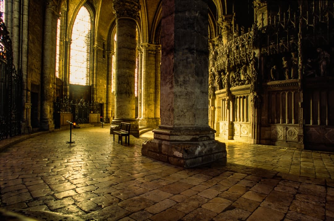 Deep blue and red medieval stained glass windows glowing inside Chartres Cathedral