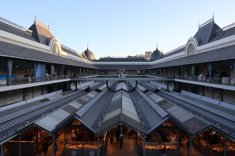 Stalls of Auvergne cheese and charcuterie under the iron roof of the Place Saint-Pierre market hall in Clermont-Ferrand