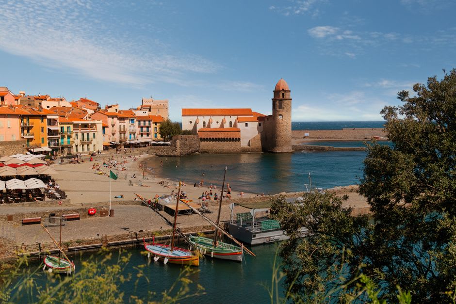 Fishing boats moored in Collioure's harbour beneath the pink-domed bell tower of Notre-Dame-des-Anges