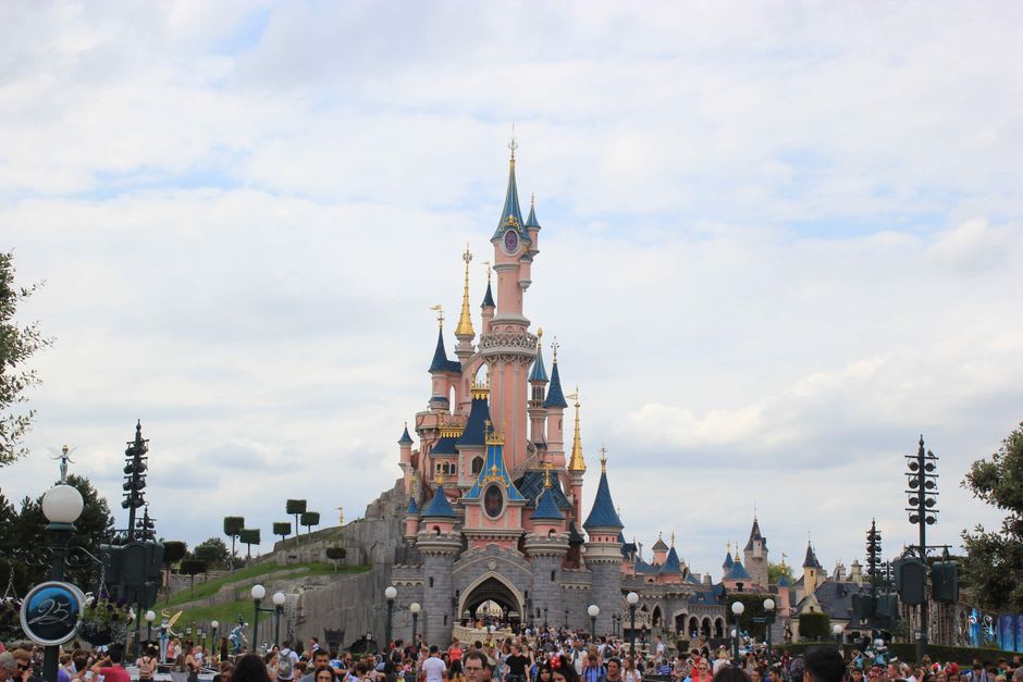 The pink and blue turrets of Sleeping Beauty's Castle at the heart of Disneyland Park, seen from Main Street